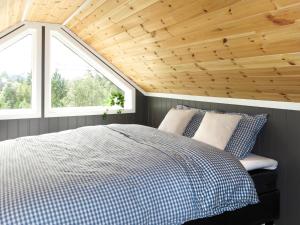 a bedroom with a bed and two windows at Chalet Doghouse by Interhome in Øyuvstad