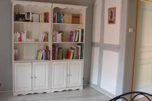 a white book shelf filled with books in a room at Gîte de charme au coeur du vignoble alsacien in Bernardvillé