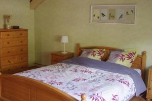 a bedroom with a bed and a dresser at Gîte de charme au coeur du vignoble alsacien in Bernardvillé