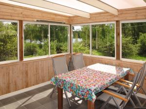 un porche cubierto con mesa y sillas en Holiday Home Munkhalla Morgonsolen by Interhome en Asarum