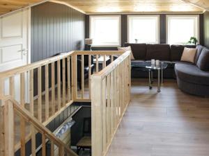 a living room with a wooden staircase and a couch at Chalet Doghouse by Interhome in Øyuvstad