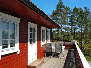 una casa roja con sillas en una terraza en Chalet Kosekroken - SOW081 by Interhome, en Fossdal