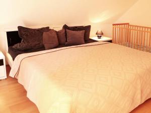 a bedroom with a large white bed with brown pillows at Holiday Home Ferienpark Verchen-3 by Interhome in Verchen