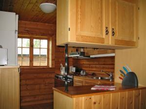 cocina con armarios de madera y encimera en Chalet Vemhån Byn - HJD062 by Interhome en Vemhån