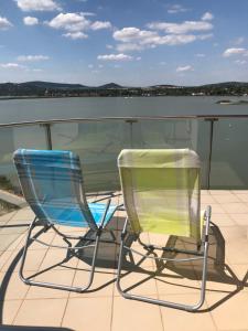 two chairs sitting on the deck of a boat at Panorama Apartman in Velence