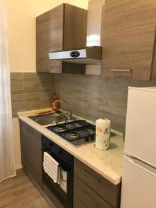 a kitchen with a stove and a sink and a refrigerator at Domus Re Di Roma in Rome