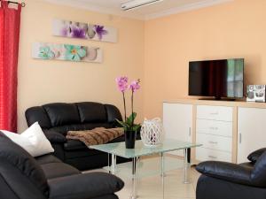 a living room with black leather furniture and a tv at Holiday Home Ferienpark Verchen-3 by Interhome in Verchen