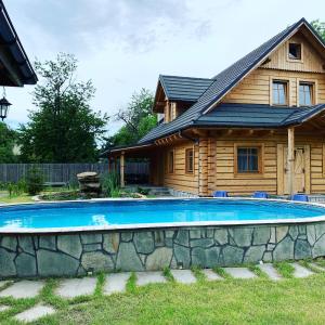a house with a swimming pool in front of a house at Gniazdko Pod Lipą in Andrychów