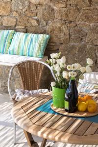 een tafel met een vaas met bloemen en fruit erop bij Sugar Blue in Mykonos-stad