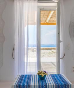 een kamer met een raam met uitzicht op de oceaan bij Sugar Blue in Mykonos-stad