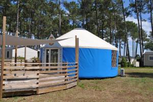 eine blau-weiße Jurte neben einem Zaun in der Unterkunft Mobilhome Côte Landaise Les Dunes de Contis in Saint-Julien-en-Born