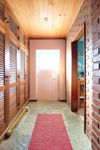 een hal met een witte deur en een rood tapijt bij Apartamento Vizir in Vila Nova de Milfontes