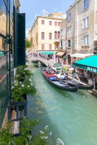 um grupo de barcos em um rio em uma cidade em Residence Suite a Venezia em Veneza