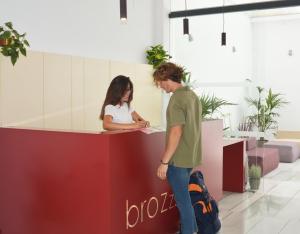 a man and a woman standing at a counter at Broz Hostel in Granada