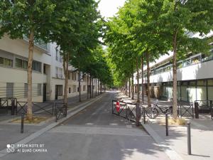 uma rua vazia com árvores em cada lado de um edifício em Le Jourdain em Paris