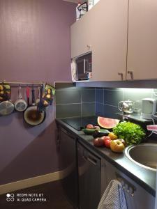 a kitchen with a counter with vegetables and a sink at Le Jourdain in Paris