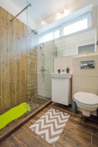uma casa de banho com um chuveiro, um WC e um lavatório. em Modern Central Ap - Terrace - Parking em Brasov
