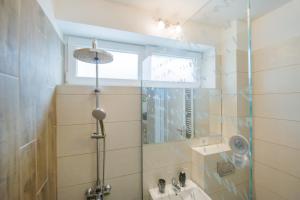 uma casa de banho com um chuveiro, um lavatório e um espelho. em Modern Central Ap - Terrace - Parking em Brasov