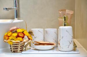 a bathroom counter with a basket of flowers and two cups at Villa Kim Yến Lagi in La Gi