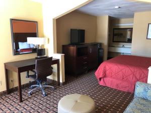 a hotel room with a bed and a desk and a bed at La Grange Executive Inn and Suites in La Grange