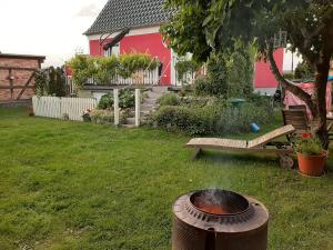 a grill in a yard with a bench and a house at Ostseeurlaub-Barth in Barth