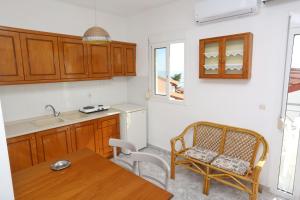 a kitchen with wooden cabinets and a table and a chair at Maison Ciel in Agia Paraskevi