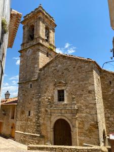 an old stone church with a tower and a door at Casa Plaza de Culla in Culla