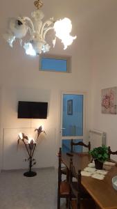 a dining room with a table and a chandelier at Casa Sant'Anna 24 in Ragusa