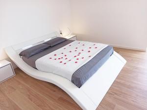 um quarto com uma cama branca com corações vermelhos em Guest House - La bella vita em Orosei