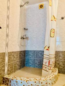 y baño con ducha y taburete de mimbre. en Otdykh u moria, en Fontanka