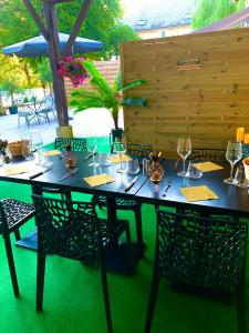 uma mesa com cadeiras e copos de vinho em La biche au bois chambres d hôtes em Cazals