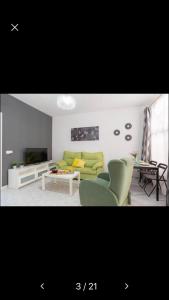 a living room with a green couch and chairs at Miami Beach 39 in Benalmádena