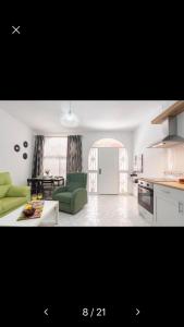 a kitchen and a living room with green furniture at Miami Beach 39 in Benalmádena