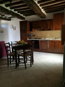 een keuken met een tafel en stoelen in een kamer bij Appto Camelia 1 Bedroom, Living Room, 4 Pax,60mq in Monte Molino