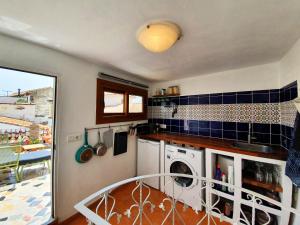 uma cozinha com máquina de lavar e secar roupa num quarto em La Casita Cactus em Vélez-Málaga