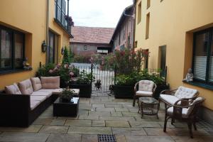 a patio with a couch and chairs in a courtyard at Weghuberhof Ferienwohnungen in Biedermannsdorf