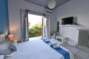 a bedroom with a large bed and a large window at jasmine apartments in Eretria
