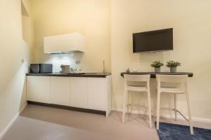a kitchen with a bar with stools and a tv at Suite Cagliari -97- in Cagliari