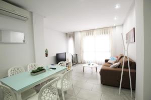 a living room with a couch and a table at Apartamento Bajo 2 Dúplex Marjal playa centro de Guardamar in Guardamar del Segura