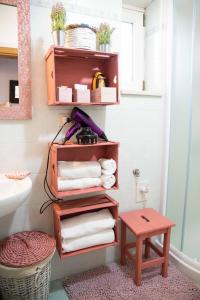 een badkamer met een plank met handdoeken en een kruk bij Sogni d'oro in Alberobello