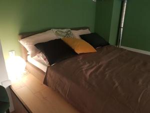 łóżko z kilkoma poduszkami w sypialni w obiekcie Apartament Atram Minimax we Wrocławiu