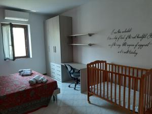 a bedroom with a crib and a desk with writing on the wall at Casa Bibì in Bergamo