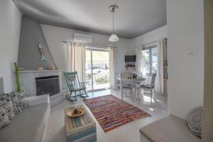 a living room with a fireplace and a table at jasmine apartments in Eretria