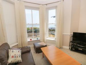 a living room with a couch and a table at 6 South Beach Court in Tenby
