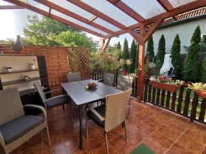 a patio with a table and chairs under a pergola at Erika Apartman Klímával in Balatonkeresztúr