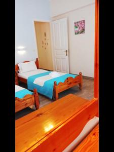 a bedroom with two beds and a table at Corfu Sunflower Apartments in Benitses