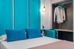 1 dormitorio con 1 cama con paredes azules y 1 maleta en Veronica Centro, en Granada