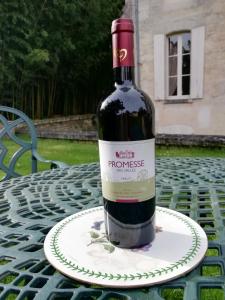 eine Flasche Wein auf einem Teller auf dem Tisch in der Unterkunft Château des Salles in Saint-Fort-sur-Gironde