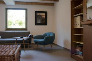 ein Wohnzimmer mit einem blauen Stuhl und einem Tisch in der Unterkunft dresden-ferien haus in Dresden