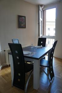 a dining room table and chairs with wine glasses on it at Apartments Bella in Užice